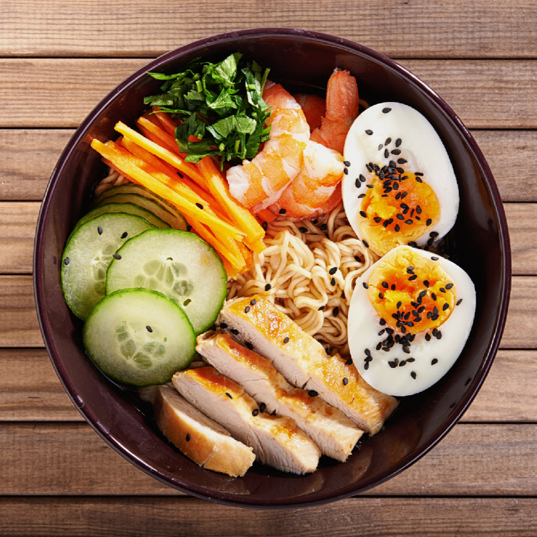 Bowl of steaming ramen noodles with toppings