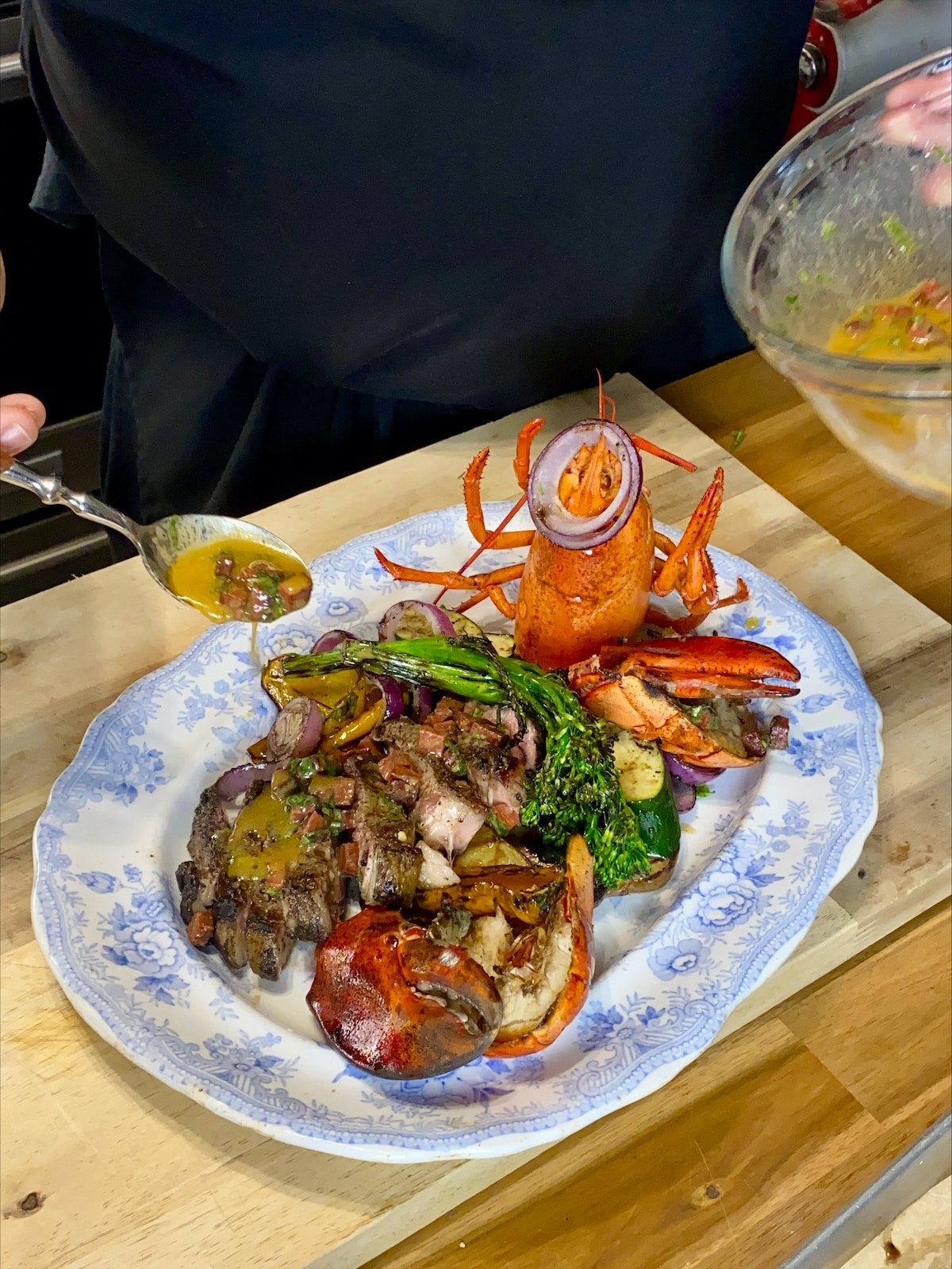 Drizzling the platter with the chorizo dressing on Surf & Turf Sharing Platter.