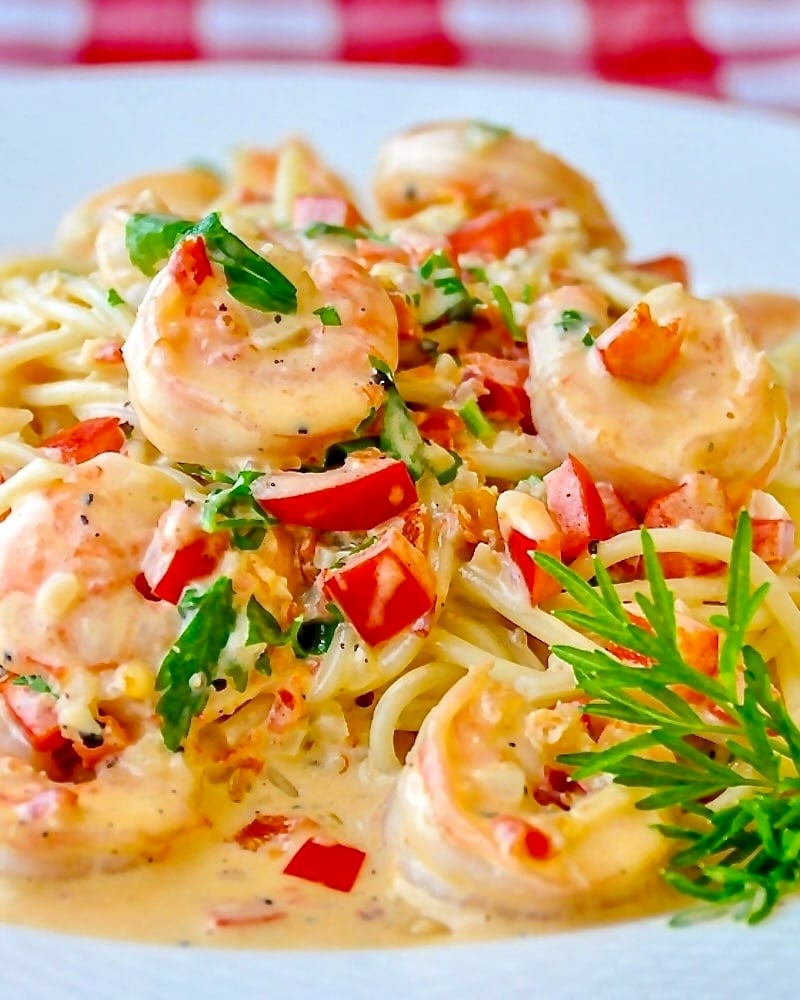 Spicy Creamy Garlic Shrimp Pasta on a white plate with herb garnish
